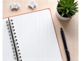 Well-organized desk with a planner and clock, symbolizing effective time management
